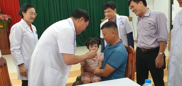 Thứ trưởng Bộ Y tế Đỗ Xuân Tuyên cho trẻ uống vitamin A tại Trạm Y tế xã Hợp Phong. (Ảnh: moh.gov.vn)