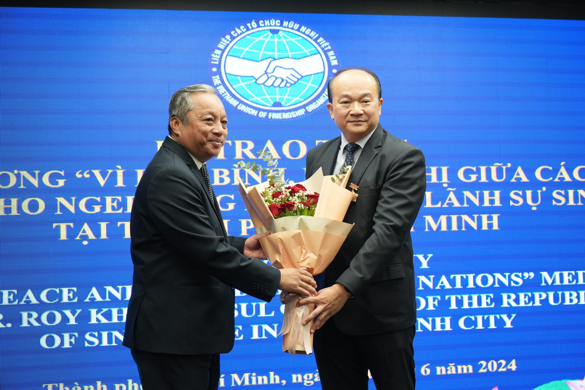 Chủ tịch Liên hiệp các tổ chức hữu nghị TPHCM Đỗ Việt Hà trao kỷ niệm chương và tặng hoa chúc mừng ông Kho Ngee Seng Roy, Tổng lãnh sự Singapore tại TP.HCM. (Ảnh: hufo.hochiminhcity.gov.vn)