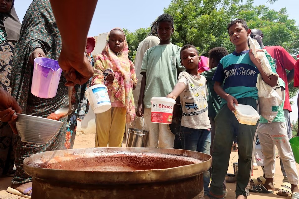 Tình nguyện viên phân phát thực phẩm cho người dân ở Omdurman, Sudan. (Ảnh: Reuters)