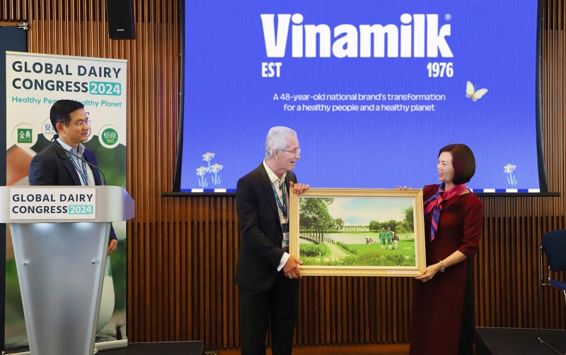 Đại diện Vinamilk trao tặng bức tranh trang trại Green Farm của Vinamilk đến chủ tịch hội nghị sữa toàn cầu - ông Richard Hall (bên trái).