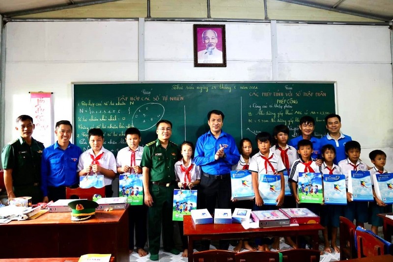 Anh Ngô Văn Cương, Bí thư Ban Chấp hành Trung ương Đoàn (thứ 7 từ trái qua) tặng quà các em học sinh lớp học tình thương.