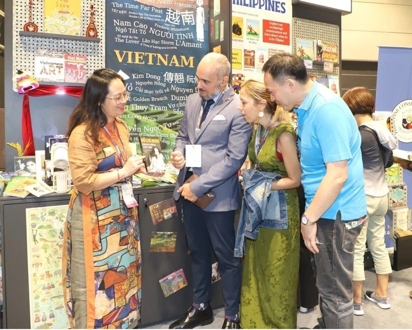 Khách tham quan hội chợ tìm hiểu một trong những tác phẩm viết về Chủ tịch Hồ Chí Minh của Việt Nam. (Ảnh: Xuân Vịnh/TTXVN)