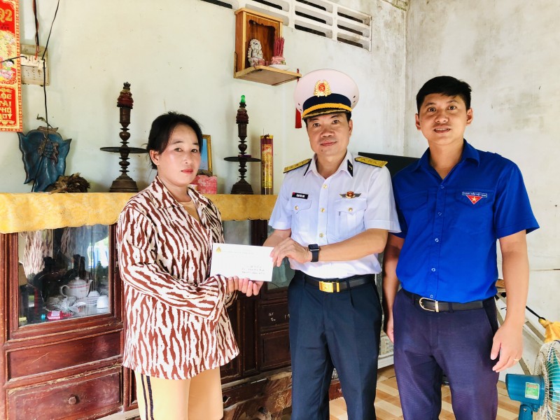 Thượng tá Phạm Văn Long, Phó Lữ đoàn trưởng, Lữ đoàn 127 tặng quà con gái của gia đình bà Phan Thị Hạnh có chồng là liệt sĩ
