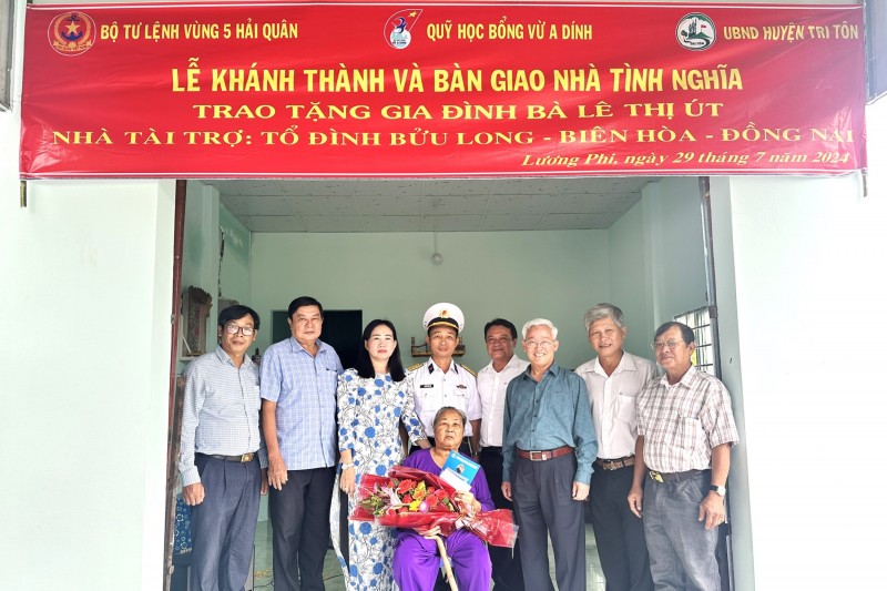 Các đại biểu chụp ảnh lưu niệm với gia đình bà Lê Thị Út tại lễ bàn giao.
