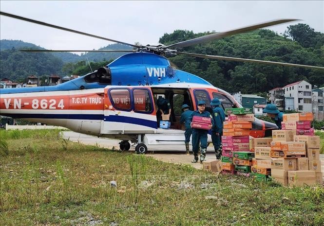 Chuyển hàng cứu trợ từ trực thăng xuống vùng lũ thuộc huyện Nguyên Bình. Ảnh: Thông tấn Quân sự/TTXVN phát