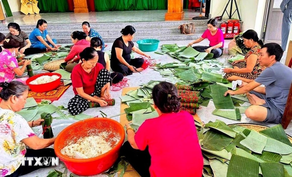 Các hội viên, phụ nữ và người dân trên địa bàn thành phố Đồng Hới, tỉnh Quảng Bình tham gia gói bánh chưng hỗ trợ người dân các tỉnh phía Bắc bị ảnh hưởng bởi thiên tai. (Ảnh: TTXVN phát)