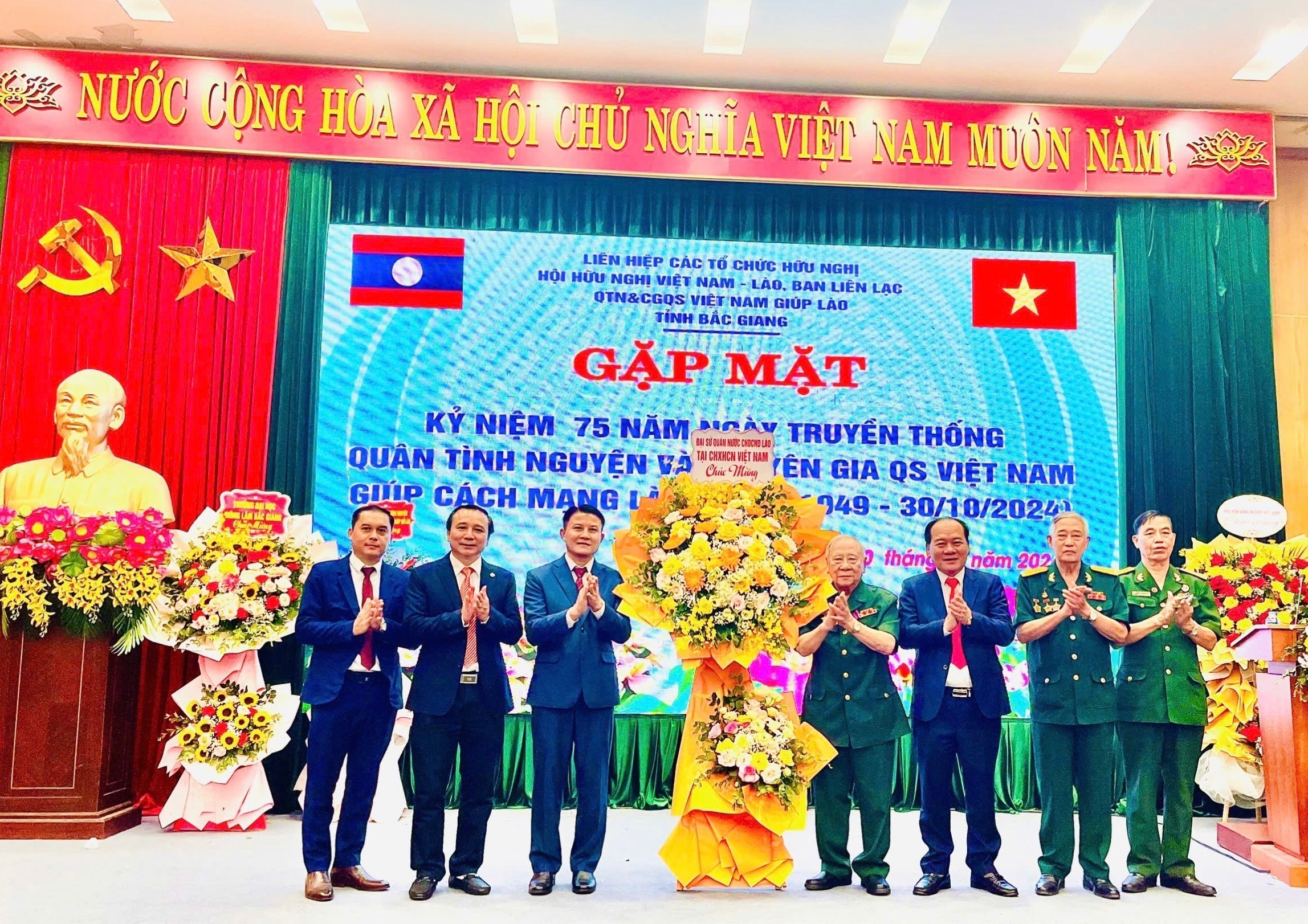 ông  Bunnhu Xaypannha, Tham tán công sứ Đại sứ quán Lào tại Việt Nam tặng hoa chúc mừng quân tình nguyện và chuyên gia quân sự Việt Nam giúp cách mạng Lào tỉnh Bắc Giang. 