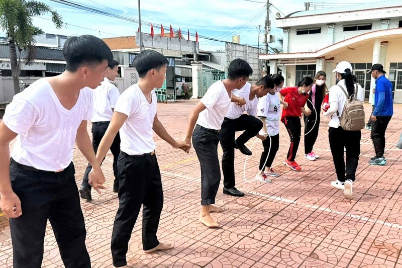 Cán bộ, chiến sĩ Trung tâm Bảo đảm Hậu cần-Kỹ thuật và hội viên Hội Liên hiệp Phụ nữ xã Hàng Vịnh (Cà Mau) tham gia trò chơi di chuyển qua vòng