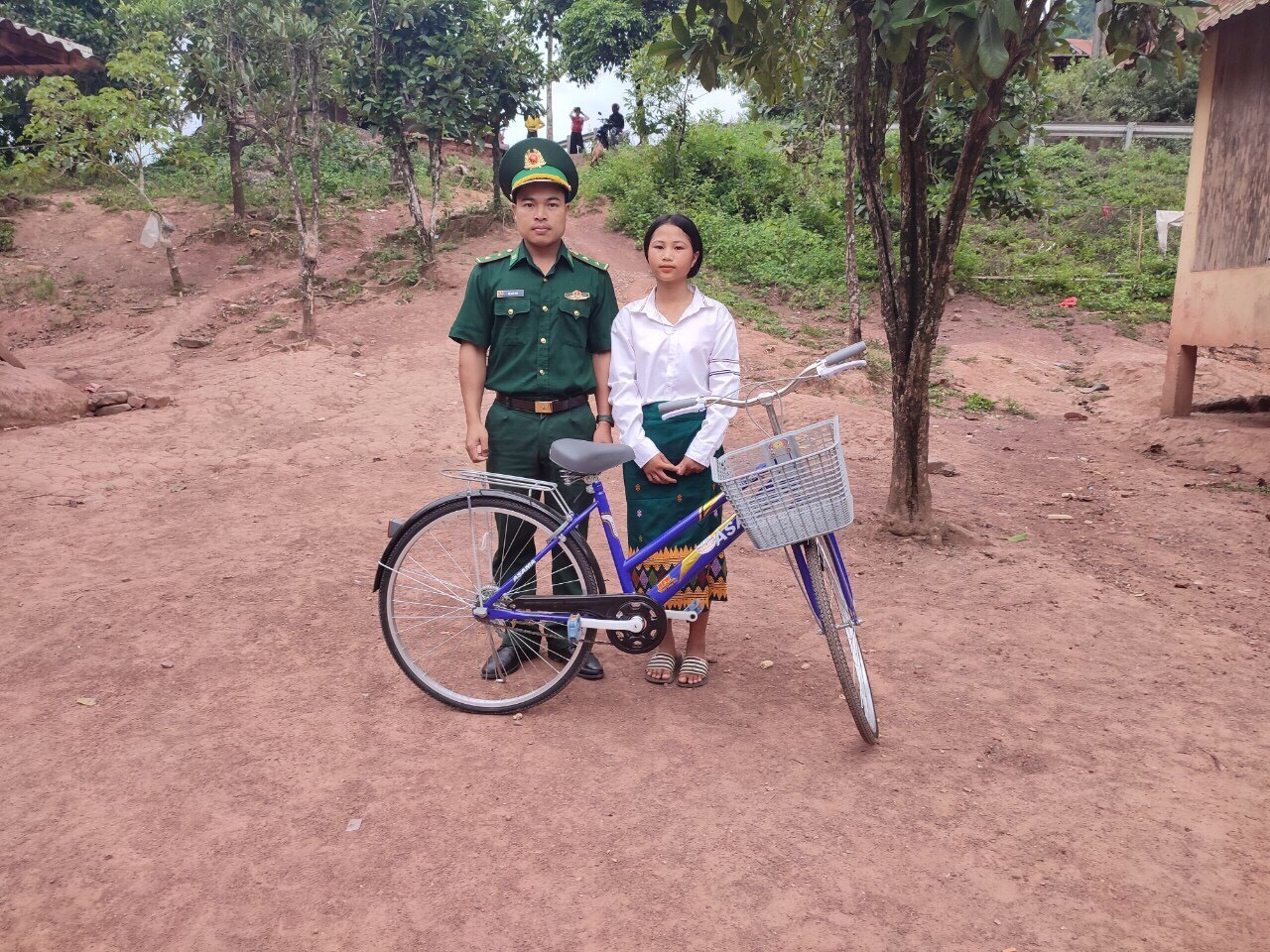  Trung úy Hồ Văn Thủ, Đồn Biên phòng La Lay trao xe đạp cho con nuôi Hồ Thị Nghin. (Ảnh: Thời Đại)