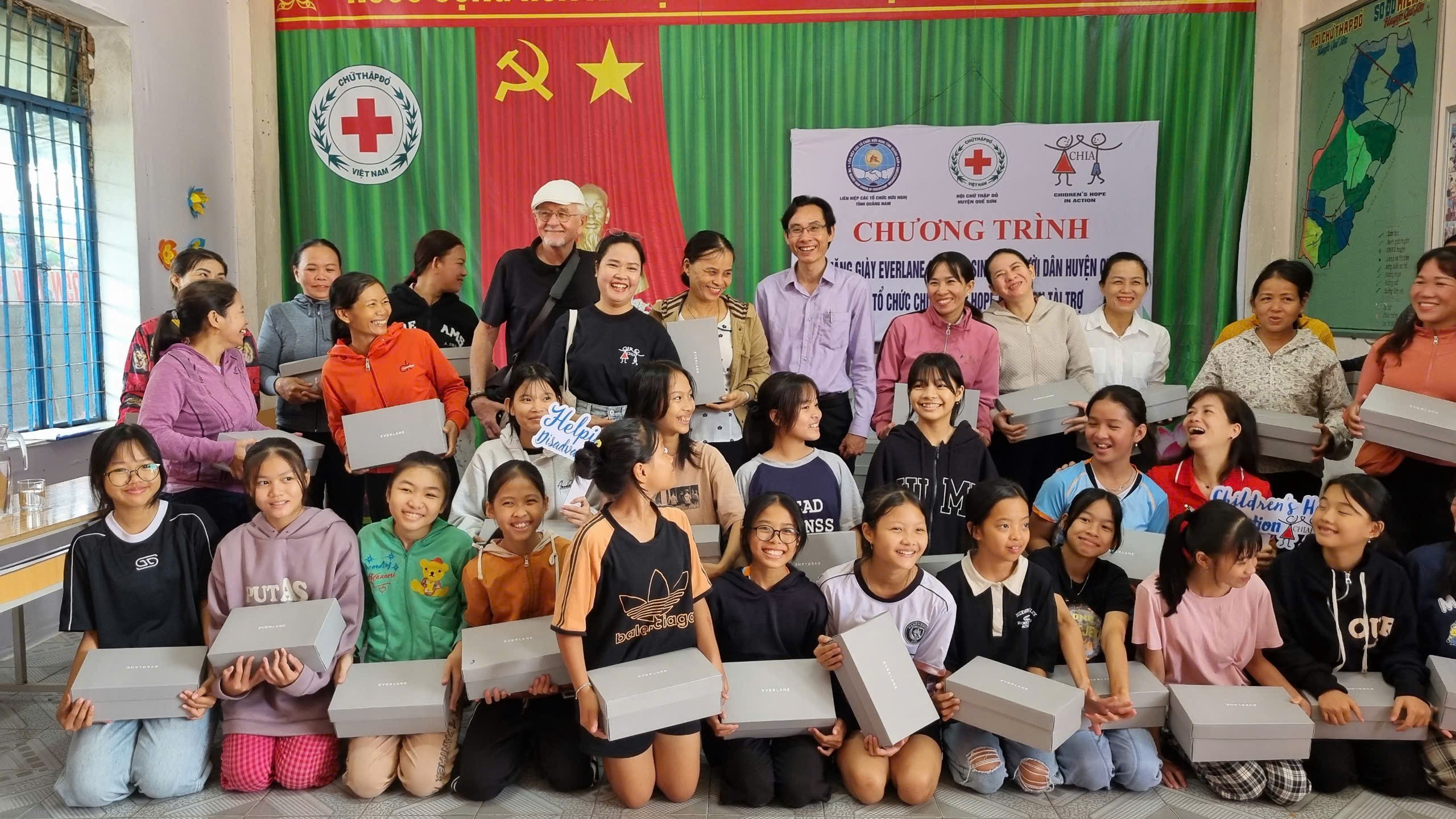 Học sinh nữ nhận giày từ đại diện tổ chức CHIA và Liên hiệp các tổ chức hữu nghị tỉnh Quảng Nam.