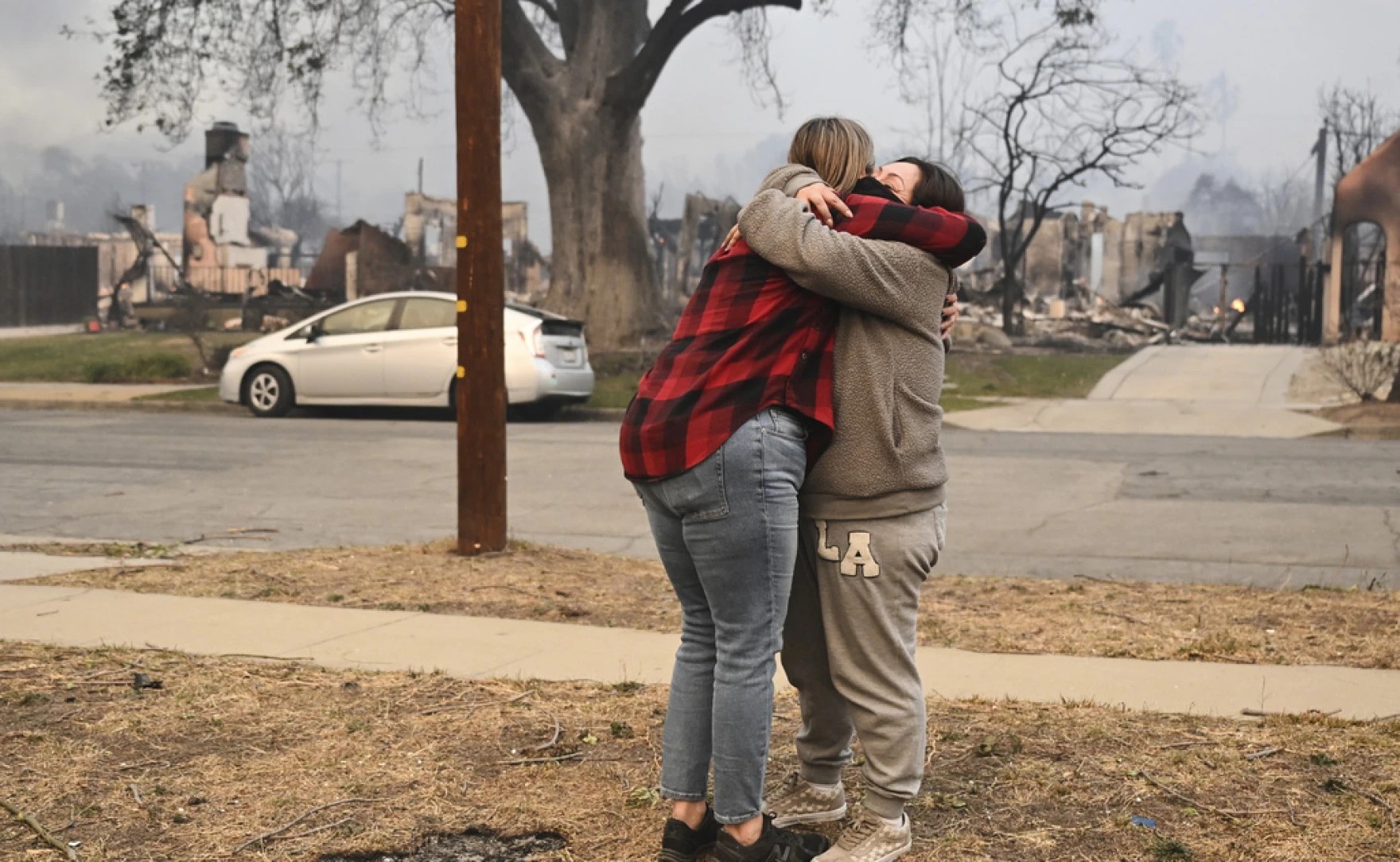 Lisa Diaz ôm một người hàng xóm bên ngoài nhà của họ khi đám cháy Eaton quét qua khu vực Altadena, California. (Ảnh: AP) Lisa Diaz ôm một người hàng xóm bên ngoài nhà của họ khi đám cháy Eaton quét qua khu vực Altadena, California. (Ảnh: AP)