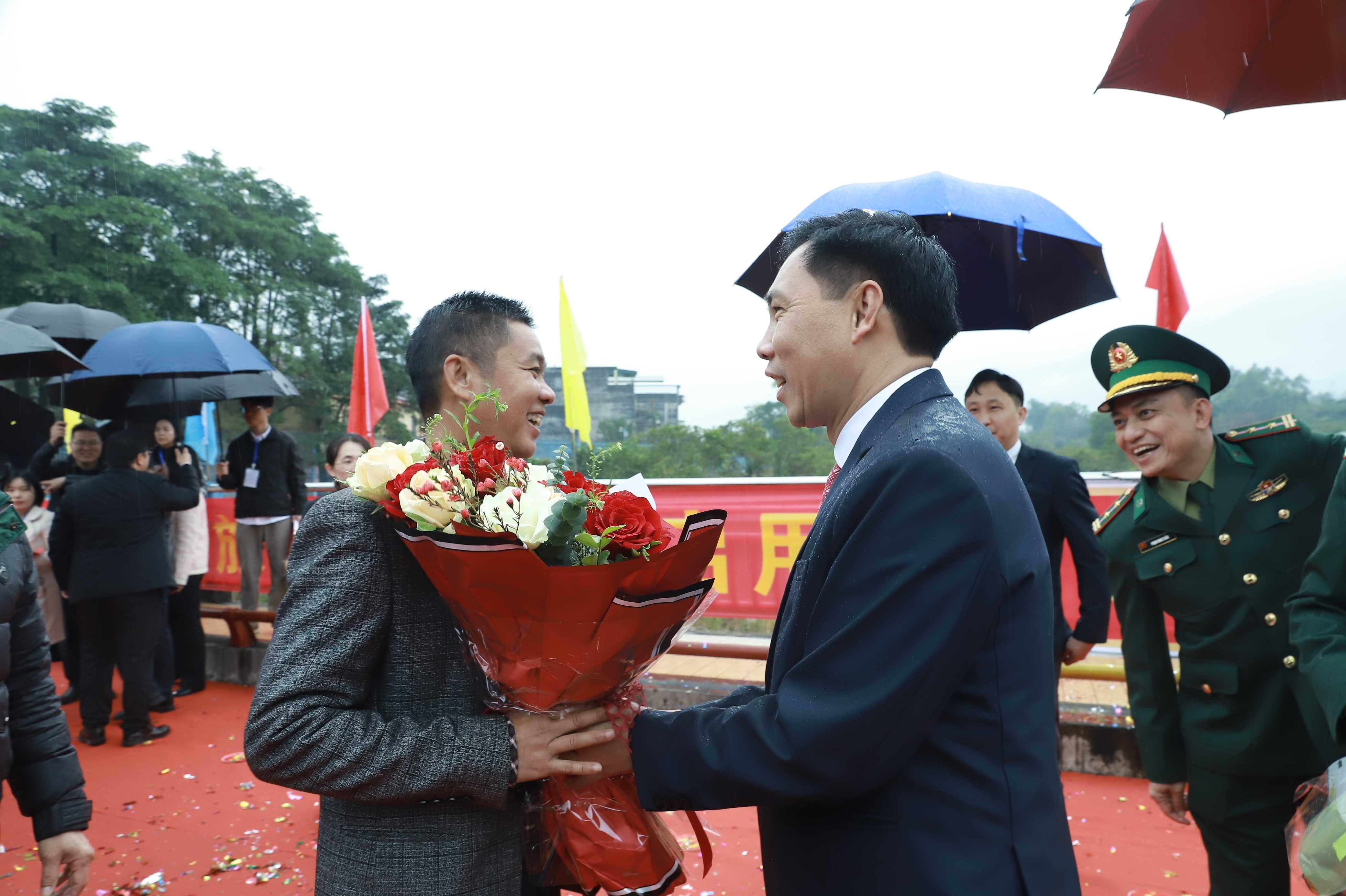 Do Xuan Truong, vice-président du Comité populaire du district, a offert des fleurs aux résidents chinois entrant au Vietnam