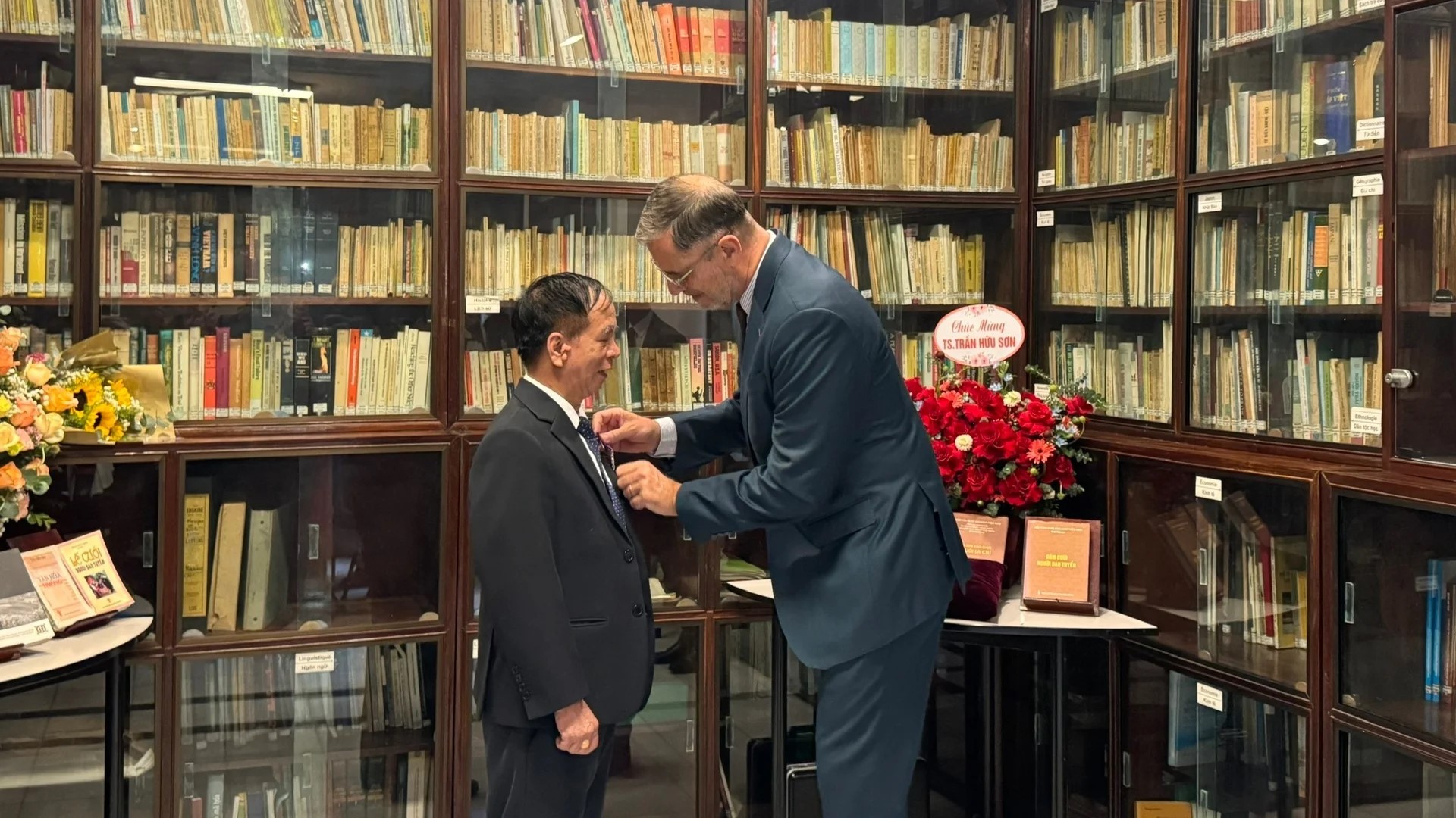 Đại sứ Olivier BROCHET trân trọng gắn Huân chương Hiệp sĩ Cành cọ Hàn lâm (Ordre des Palmes académiques) của Nhà nước Pháp cho Tiến sĩ Trần Hữu Sơn.