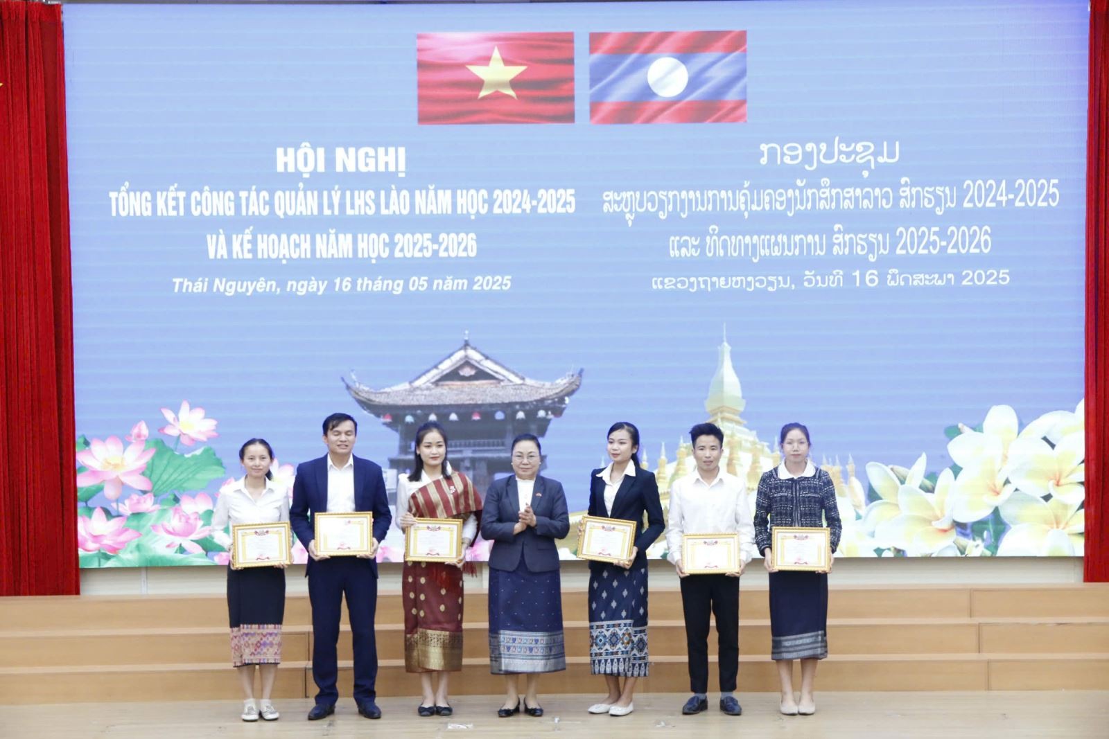 Đại sứ Khamphao Ernthavanh tặng bằng khen cho lưu học sinh Lào có thành tích xuất sắc trong học tập. (Ảnh: tnue.edu.vn)