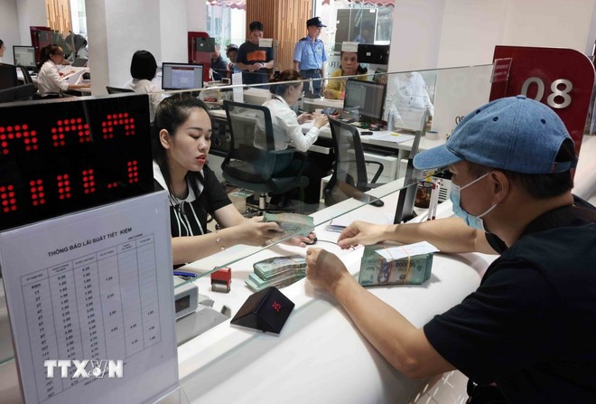 Khách hàng giao dịch tại Agribank chi nhánh Hà Nội. (Ảnh: TTXVN)