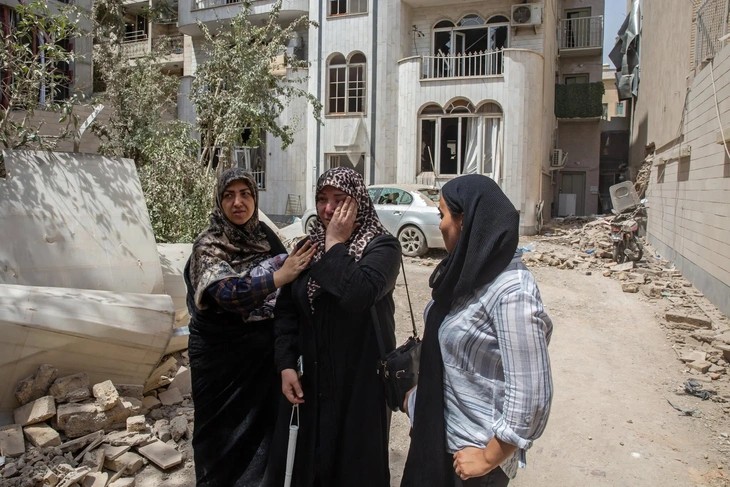 Một phụ nữ ở Tehran bật khóc trước ngôi nhà trúng không kích của Israel - Ảnh: NEW YORK TIMES