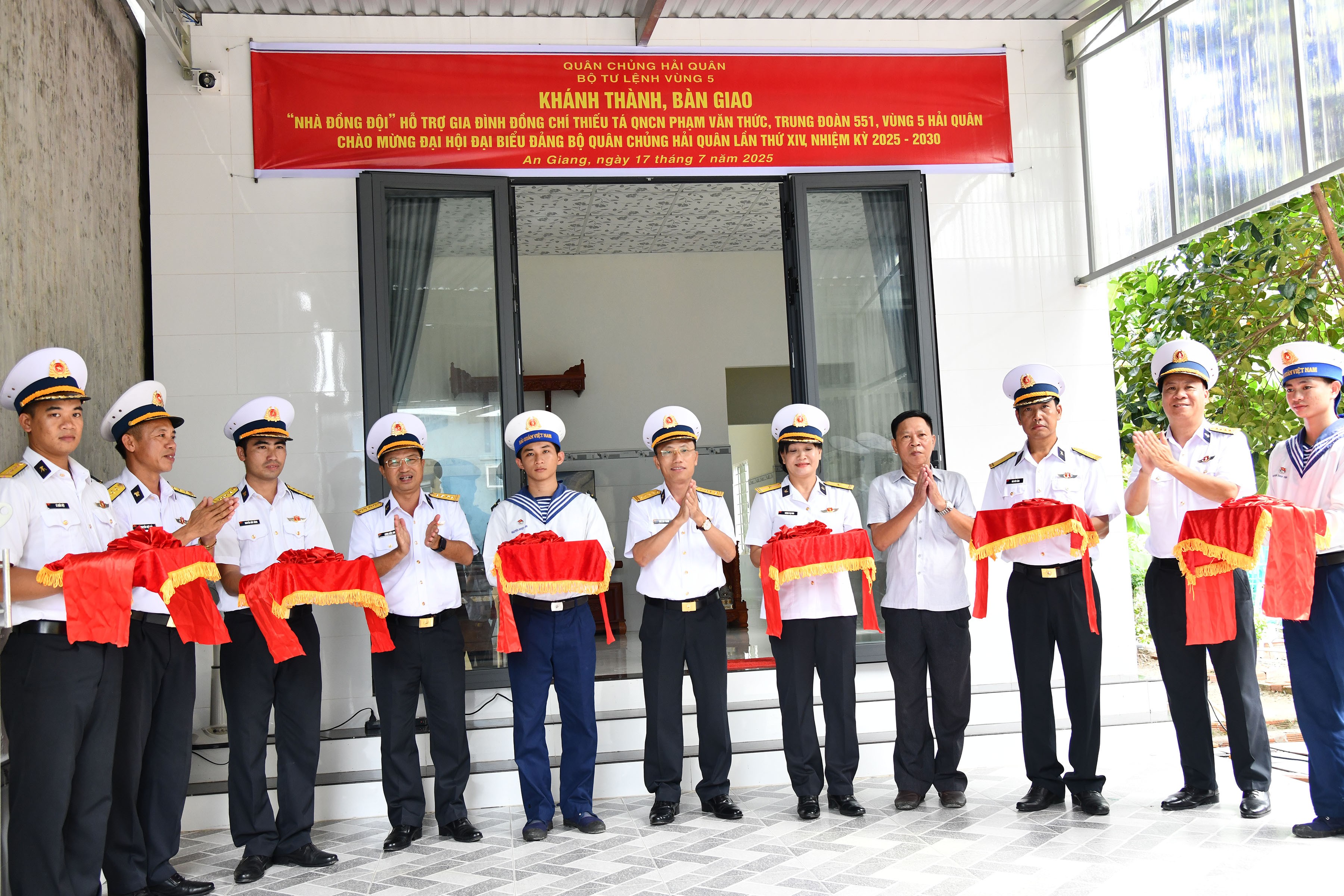 Đại tá Ngô Văn Thành (đứng giữa) và các đại biểu cắt băng khánh thành nhà đồng đội. (Ảnh: Kiên Định)