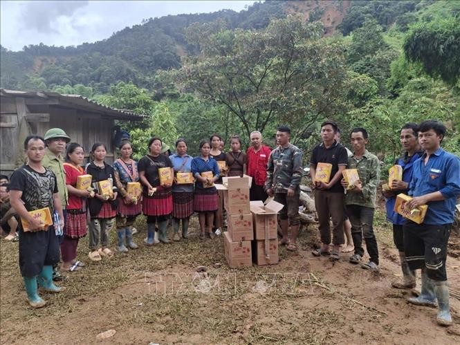 Đại diện Hội Chữ thập đỏ Điện Biên trao hàng cứu trợ cho người dân. (Ảnh: TTXVN)