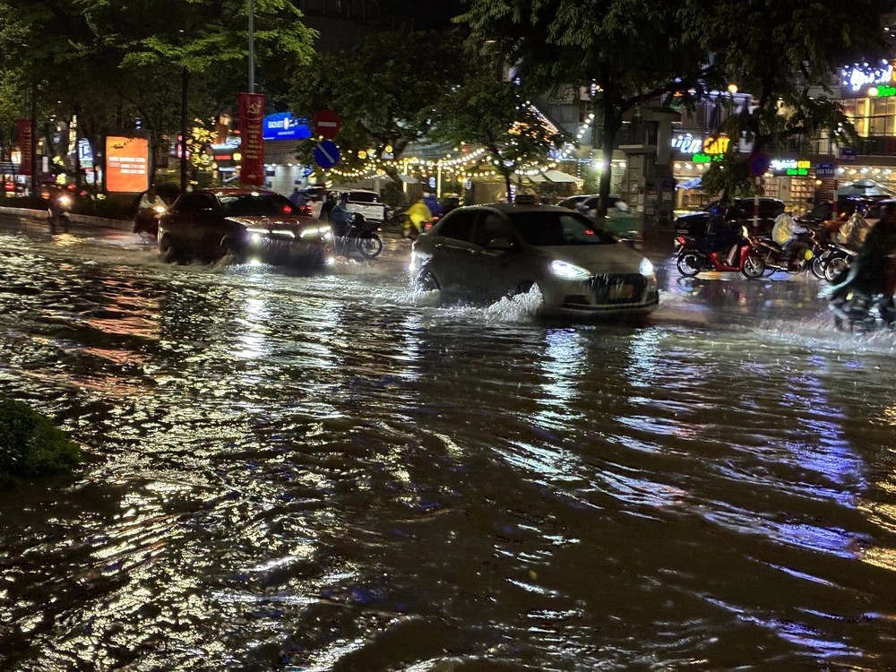 Cơn mưa lớn khiến phố Đào Tấn ngập sâu, các phương tiện di chuyển khó khăn (tối 05/8). (Ảnh: TTXVN)