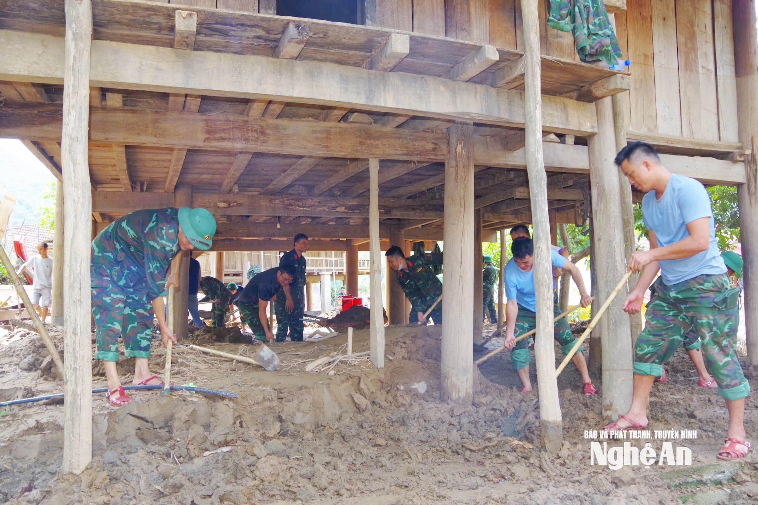 Cán bộ, chiến sĩ Bộ Chỉ huy Quân sự tỉnh Nghệ An giúp gia đình ông Lô Thế Anh ở bản Xiềng Tắm, xã Mỹ Lý nạo vét bùn đất, tu sửa nhà cửa sau khi nước lũ rút. (Ảnh: Báo và Phát thanh, Truyền hình Nghệ An)
