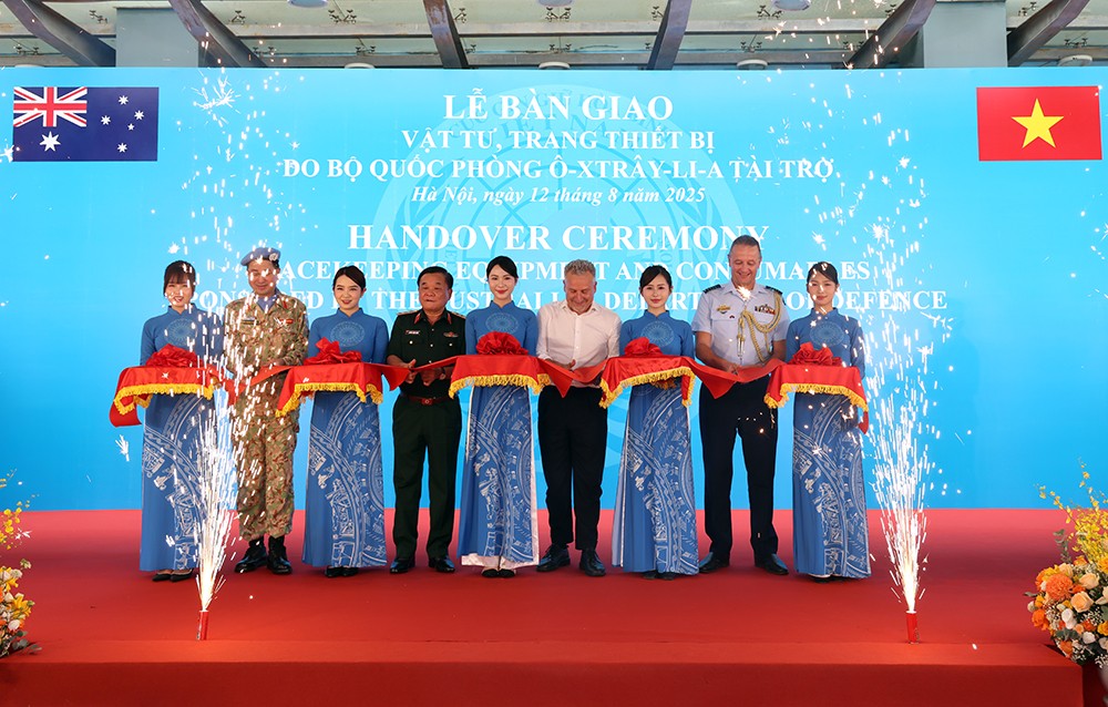 Thượng tướng Hoàng Xuân Chiến (thứ tư từ trái sang) cùng Phó Tổng Thư ký Quốc phòng Australia Hugh Jeffrey (thứ sáu từ trái sang) và các đại biểu cắt băng bàn giao.