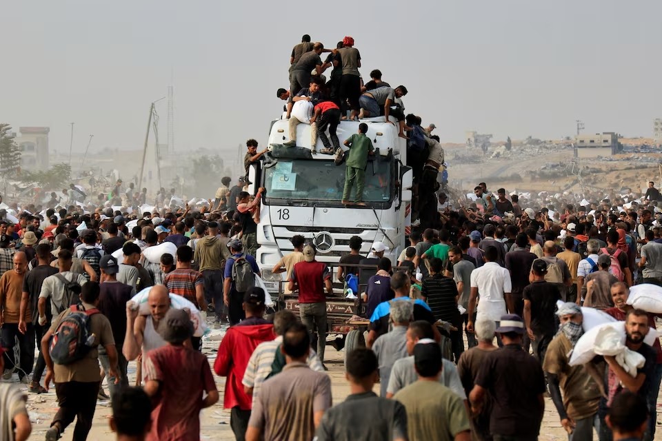 Người dân Palestine tranh nhau nhận hàng cứu trợ tại Khan Younis, nam Dải Gaza, ngày 12/8/2025. (Ảnh: Reuters)