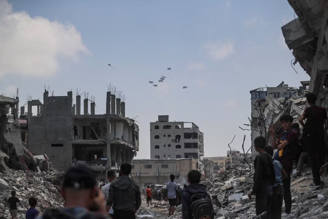 Người dân Palestine quan sát hàng viện trợ được thả từ máy bay xuống Thành phố Gaza, ngày 8/8/2025. Ảnh: Reuters