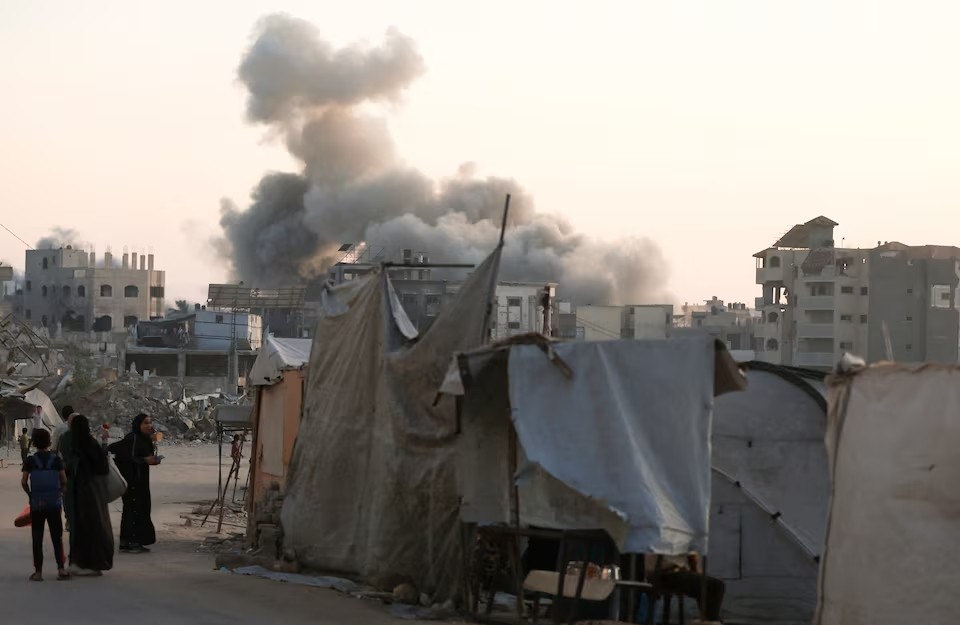 Người dân Palestine quan sát khói bốc lên sau một cuộc không kích của Israel tại Thành phố Gaza, ngày 20/8/2025. (Ảnh: Reuters)