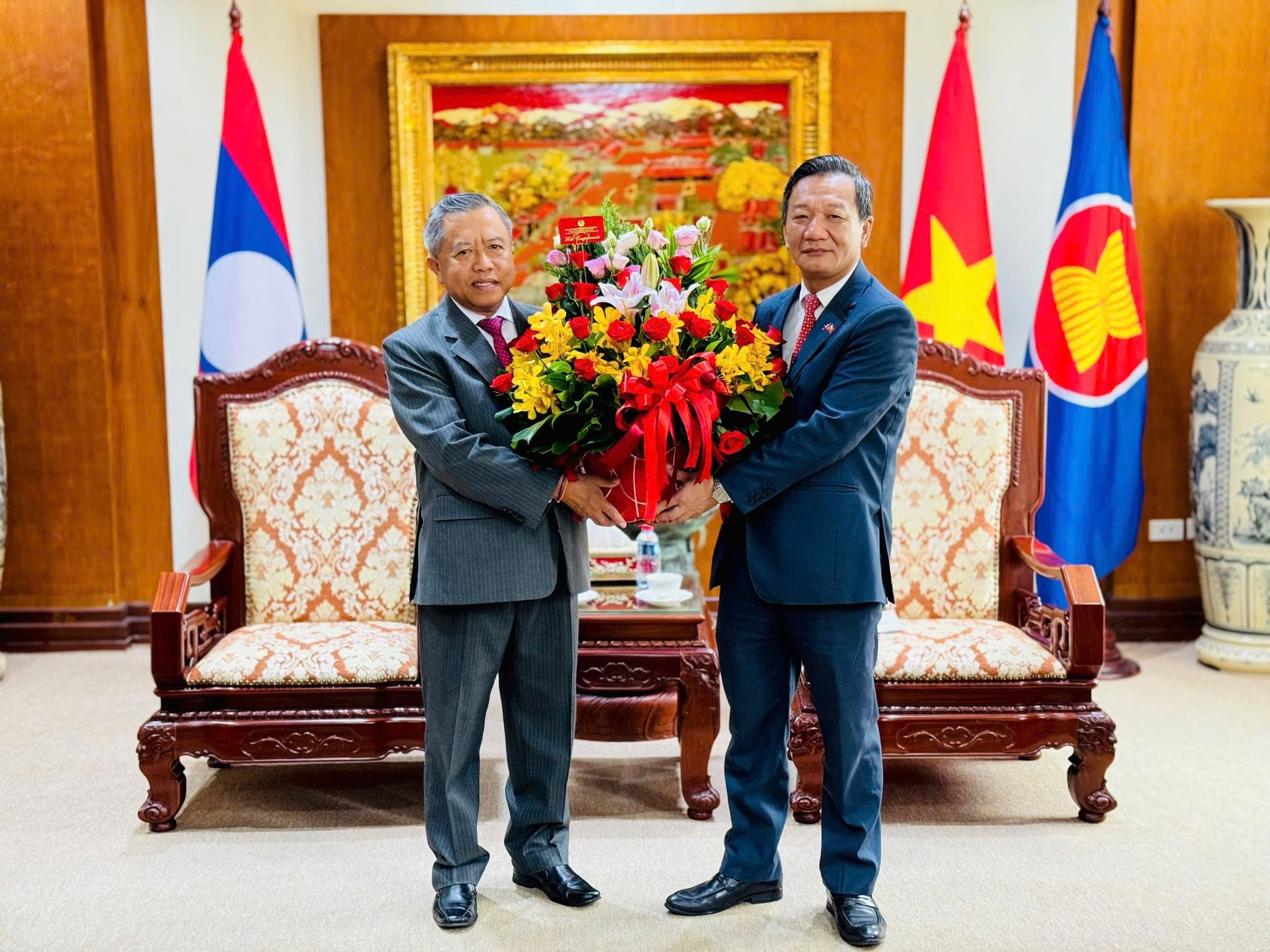 Ông Bò-viêng-khăm Vông-đa-la, Uỷ viên Trung ương Đảng, Bộ trưởng Bộ Công nghệ và Truyền thông, Chủ tịch Hội hữu nghị Lào - Việt Nam chúc mừng Đại sứ Nguyễn Minh Tâm. (Ảnh: Đại sứ quán Việt Nam tại Lào)