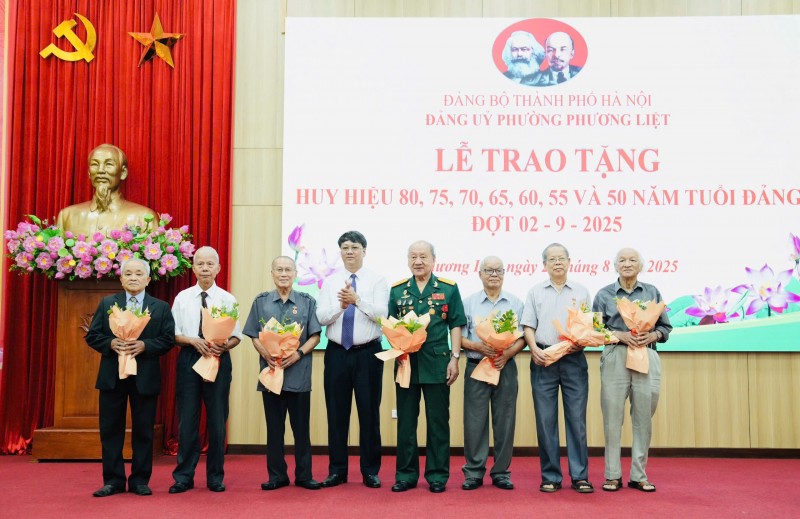 Bí thư Đảng ủy, Chủ tịch HĐND phường Phương Liệt Nguyễn Minh Tiến trao Huy hiệu Đảng tặng các đảng viên lão thành. (Ảnh: T.L)