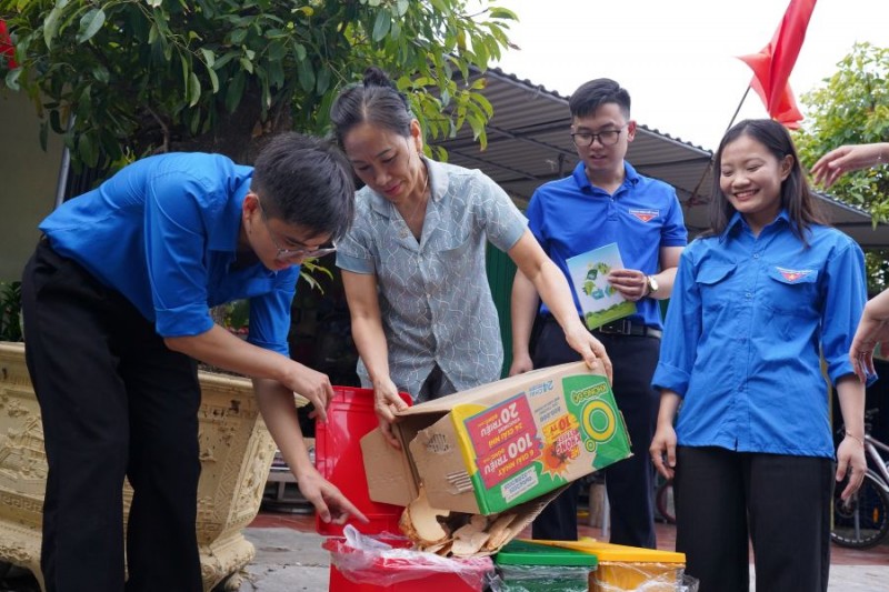 Ảnh 1. Các sinh viên tình nguyện Trường Đại học Văn hoá Hà Nội trực tiếp hướng dẫn người dân trên đảo Bạch Long Vĩ về phân loại rác sinh hoạt.