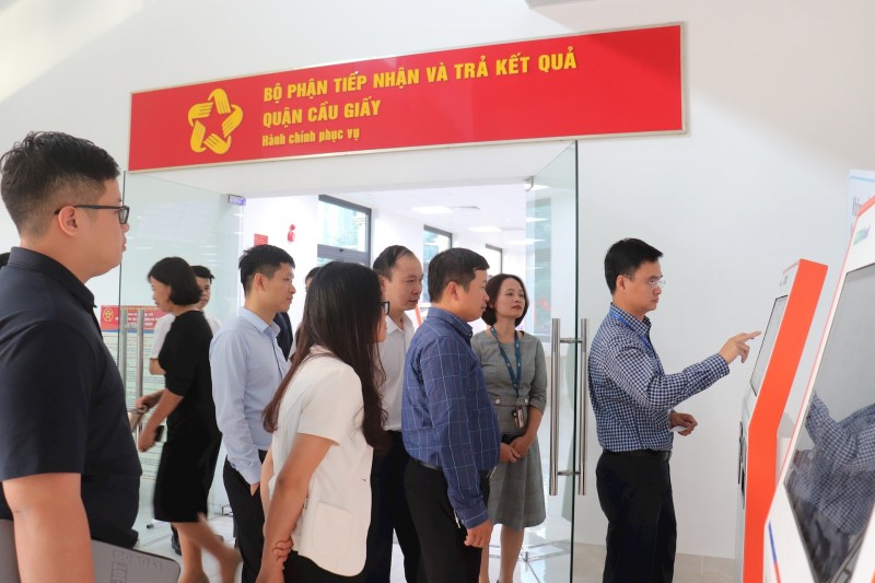 Đoàn khảo sát nghe giới thiệu về ki ốt thông minh, lấy số bằng căn cước công dân. (Ảnh: T.L)