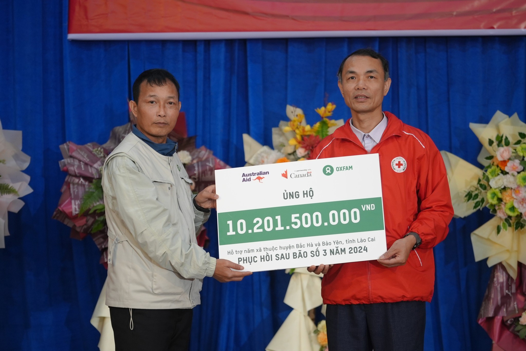Đại diện Oxfam tại Việt Nam (trái) trao hơn 10 tỷ đồng đến đại diện Hội chữ thập đỏ tỉnh Lào Cai nhằm phục hồi và tái thiết cuộc sống cho người dân tại Lào Cai sau bão Yagi,