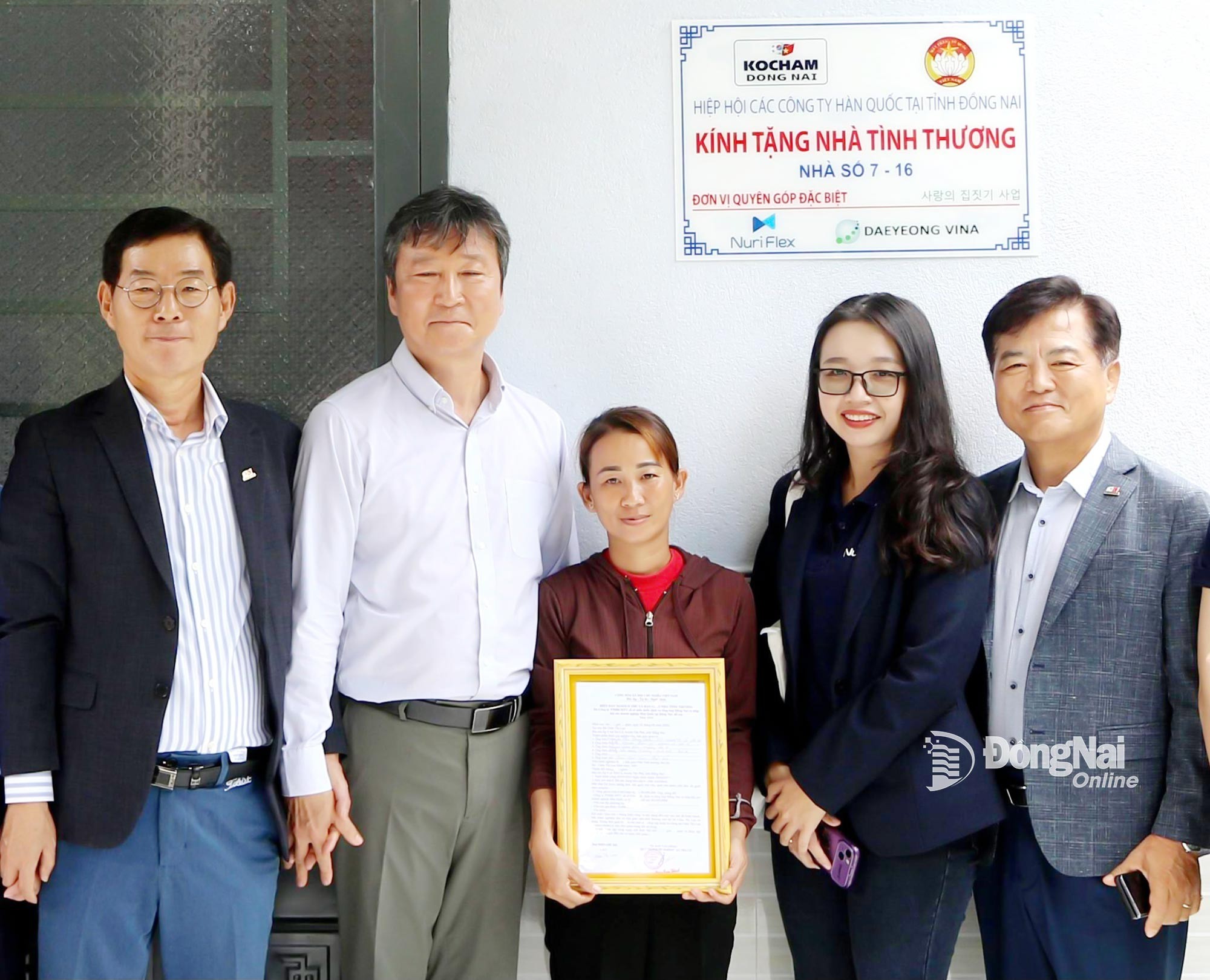 Đại diện Hiệp hội Thương mại Hàn Quốc tại Việt Nam và Hiệp hội các doanh nghiệp Hàn Quốc tại Đồng Nai cùng chính quyền địa phương trao biên bản bàn giao nhà cho một người dân xã Định Quán. Ảnh: Văn Truyên