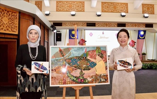 Phu nhân Nguyễn Thị Thanh Nga và bà Rozana bintin Kamal, Phu nhân Phó Chủ tịch Hạ viện Malaysia hoàn thành trải nghiệm mẫu vẽ vải truyền thống. Ảnh: TTXVN