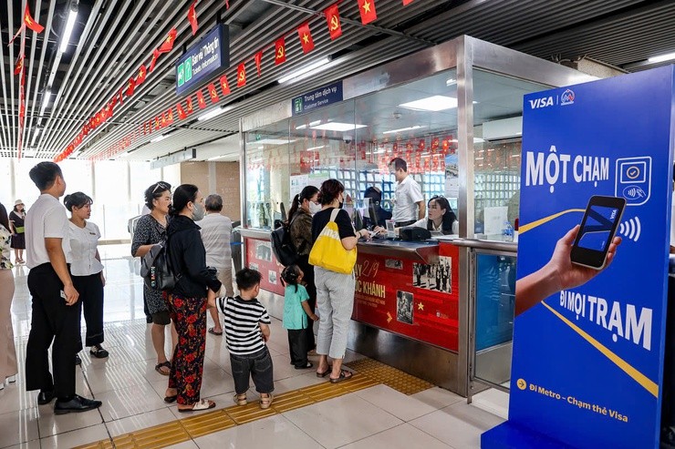 Hành khách trải nghiệm công nghệ định danh khi đi tàu, thanh toán một chạm bằng thẻ ngân hàng, ứng dụng vé điện tử. (Ảnh: T.L)