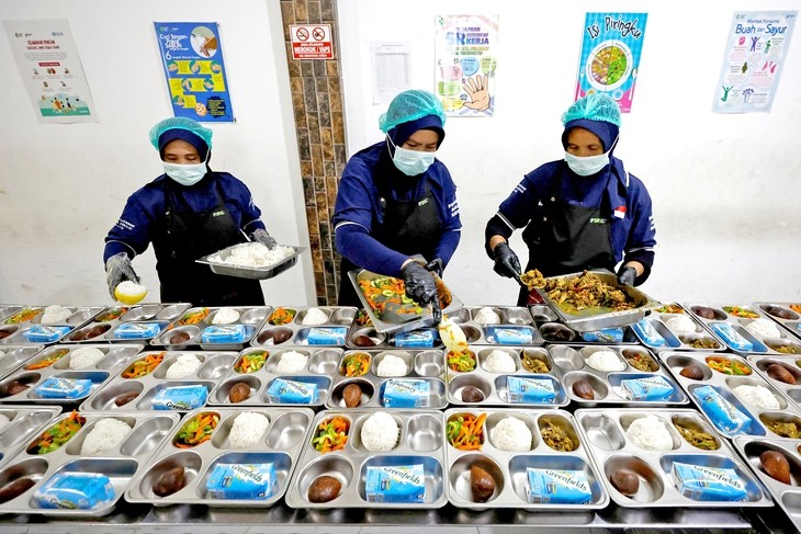 Chuẩn bị bữa ăn trong chương trình bữa ăn học đường miễn phí ở Indonesia - Ảnh: REUTERS
