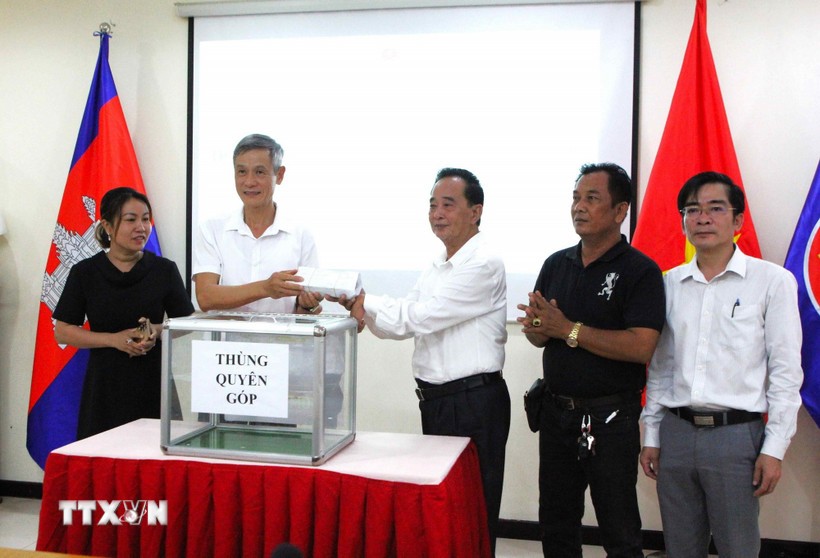 Đại diện KVA trao số tiền quyên góp ủng hộ cho lãnh đạo Đại sứ quán Việt Nam tại Campuchia. (Ảnh: Hoàng Minh/TTXVN)