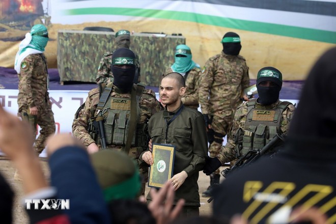 Lữ đoàn Al-Qassam, một cánh quân của Phong trào Hamas, trao trả con tin Israel cho Uỷ ban Chữ thập đỏ quốc tế tại trại tị nạn Nuseirat ở miền Trung Dải Gaza, ngày 22/2/2025. (Ảnh: THX/TTXVN)