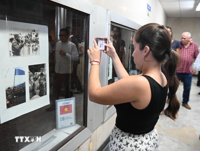 Khách tham quan những bức ảnh lịch sử của mối hệ Việt Nam - Cuba. (Ảnh: TTXVN)