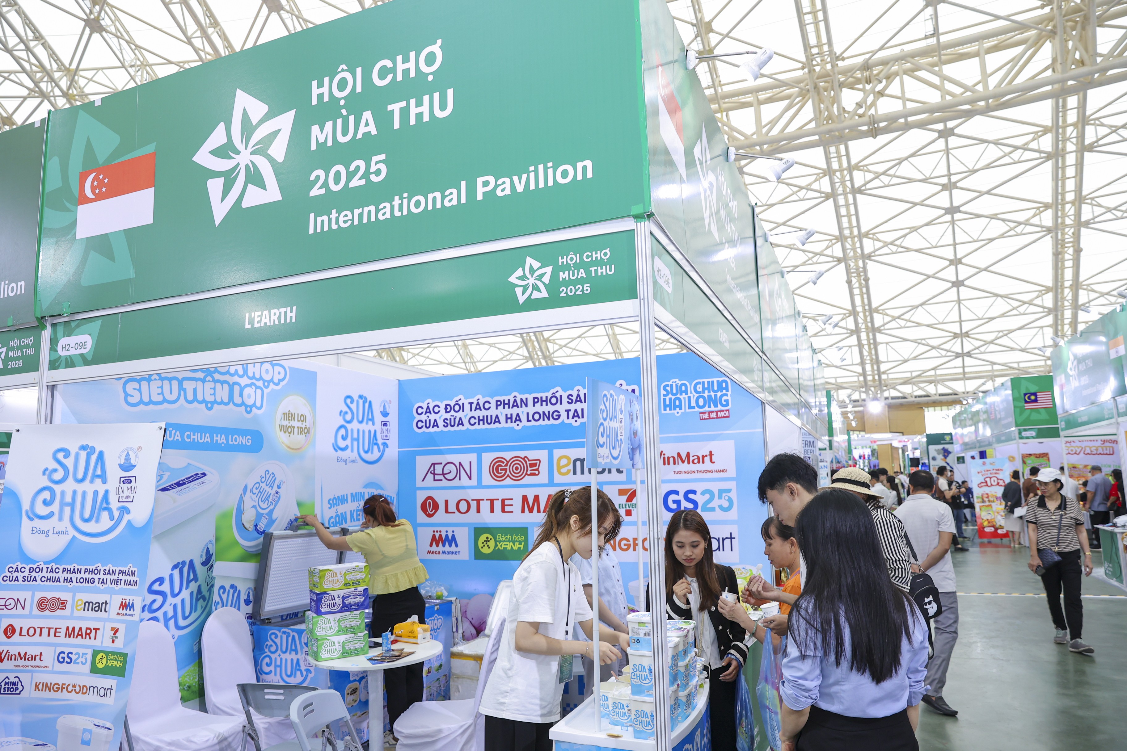 Du khách dừng chân tại gian hàng Singapore để ăn thử sản phẩm sữa chua. Nhân viên gian hàng hướng dẫn và phục vụ khách trải nghiệm trực tiếp ngay tại quầy. Du khách dừng chân tại gian hàng Singapore để ăn thử sản phẩm sữa chua. Nhân viên gian hàng hướng dẫn và phục vụ khách trải nghiệm trực tiếp ngay tại quầy.