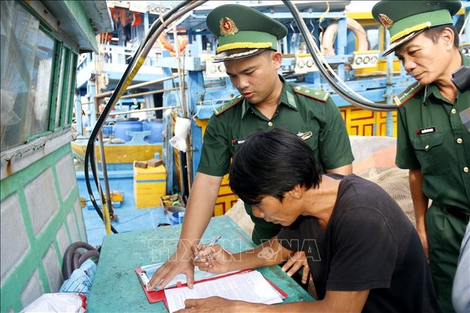 Cán bộ Đồn Biên phòng Thanh Hải hướng dẫn ngư dân ký cam kết không vi phạm IUU.