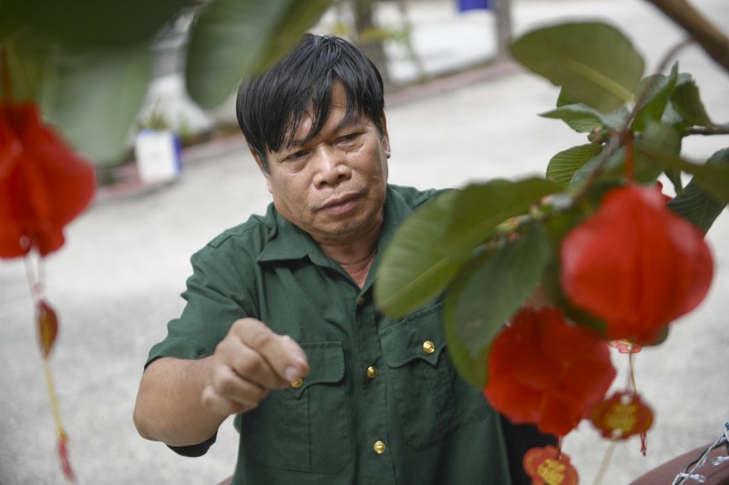 Ảnh 1A hoặc 1B: Bác Nguyễn Công Thắng – cựu chiến binh đang được chăm sóc tại Trung tâm Điều dưỡng Thương binh và Người có công Long Đất – chăm chút cho góc Tết trước phòng ở (Ảnh: Minh Anh).