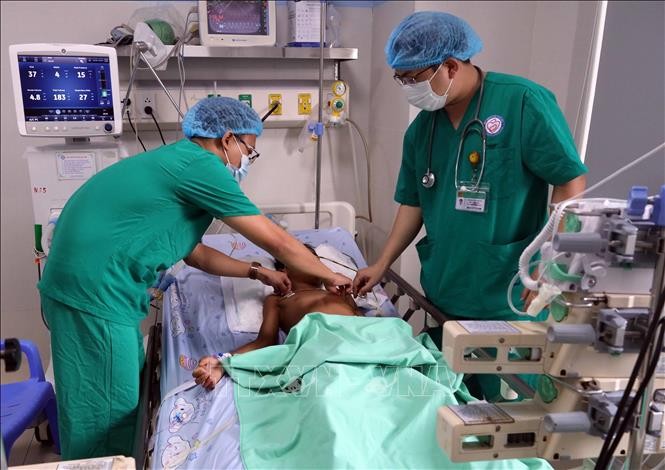 Các y, bác sĩ khoa Nhi Cấp cứu - Hồi sức tích cực và Chống độc, Bệnh viện Phụ sản - Nhi Đà Nẵng kiểm tra sức khỏe cho hai bệnh nhi đang được điều trị tại bệnh viện. Ảnh: Trần Lê Lâm/TTXVN