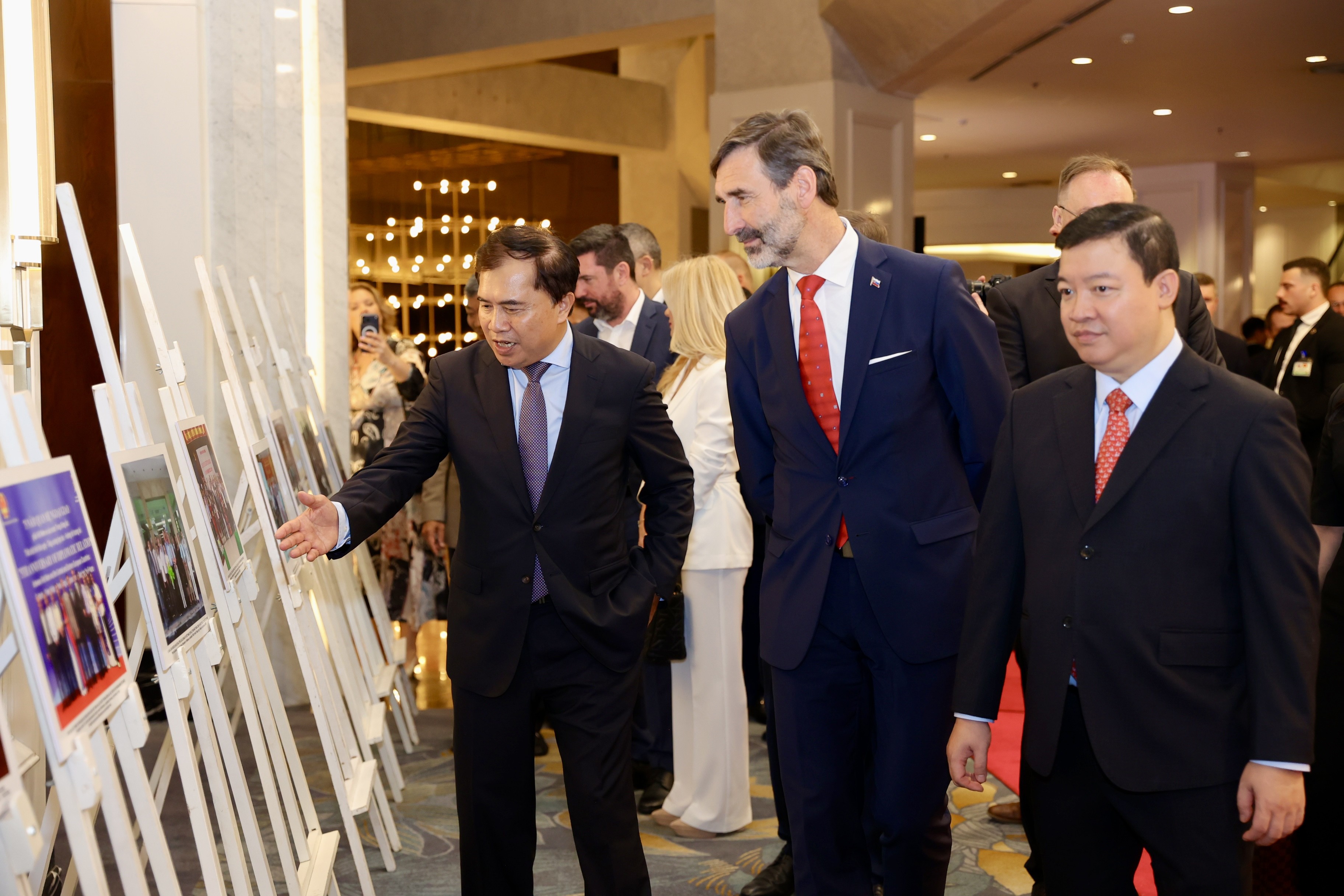 Chủ tịch Hội Hữu nghị Việt Nam-Slovakia Lê Quang Hùng giới thiệu với Bộ trưởng Ngoại giao và các vấn đề châu Âu nước Cộng hòa Slovakia Juraj Blanár những bức ảnh về quan hệ hữu nghị Việt Nam-Slovakia được trưng bày trong khuôn khổ sự kiện. (Ảnh: KHÁNH LAN)