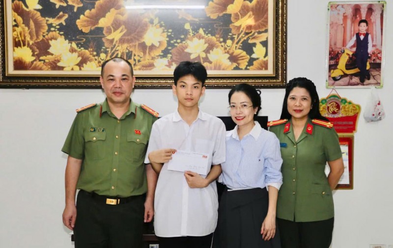  Thượng tá Lưu Hồng Quân - Phó trưởng ban Biên tập An ninh Thủ đô cùng bà Nguyễn Cẩm Phượng - Phó Giám đốc Đối ngoại, Tập đoàn Tân Hiệp Phát trao quà cho cháu Gia Bảo - con đồng chí Phan Đức Sơn, cán bộ Phòng Cảnh sát Cơ động, Công an TP Hà Nội qua đời cách đây hơn 12 năm