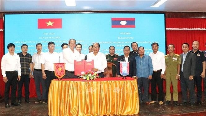Phó Trưởng ban Quản lý Khu kinh tế mở Chu Lai Thiều Việt Dũng và Giám đốc Sở Tài chính tỉnh Xekong Khamhou Onmani trao đổi Biên bản ký kết. Ảnh: Xuân Tú/PV TTXVN tại Lào