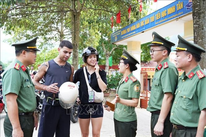 Cán bộ Phòng Quản lý Xuất nhập cảnh Công an tỉnh Tuyên Quang tuyên truyền, hướng dẫn du khách nước ngoài thực hiện các quy định tại khu vực biên giới. Ảnh: Hồng Hạnh/TTXVN phát