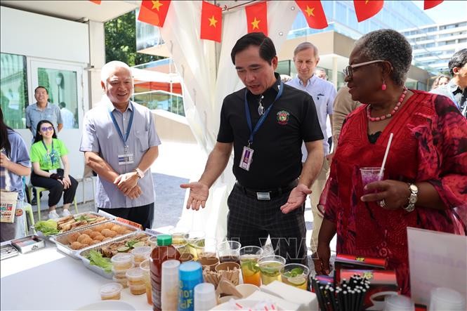 Tham tán Công sứ Phạm Quang Huy (áo đen) giới thiệu gian hàng của Việt Nam với Tổng Giám đốc WTO Ngozi Okonjo-Iweala. Tham tán Công sứ Phạm Quang Huy (áo đen) giới thiệu gian hàng của Việt Nam với Tổng Giám đốc WTO Ngozi Okonjo-Iweala.