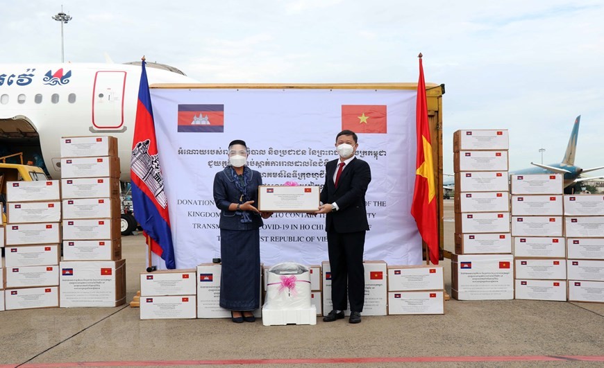 Bà Youk Sambath, Quốc vụ khanh Bộ Y tế Campuchia (trái), trao tượng trưng số hàng của Chính phủ Hoàng gia và nhân dân Campuchia hỗ trợ công tác phòng, chống dịch COVID-19 của Thành phố Hồ Chí Minh cho ông Dương Anh Đức, Phó Chủ tịch UBND Thành phố Hồ Chí